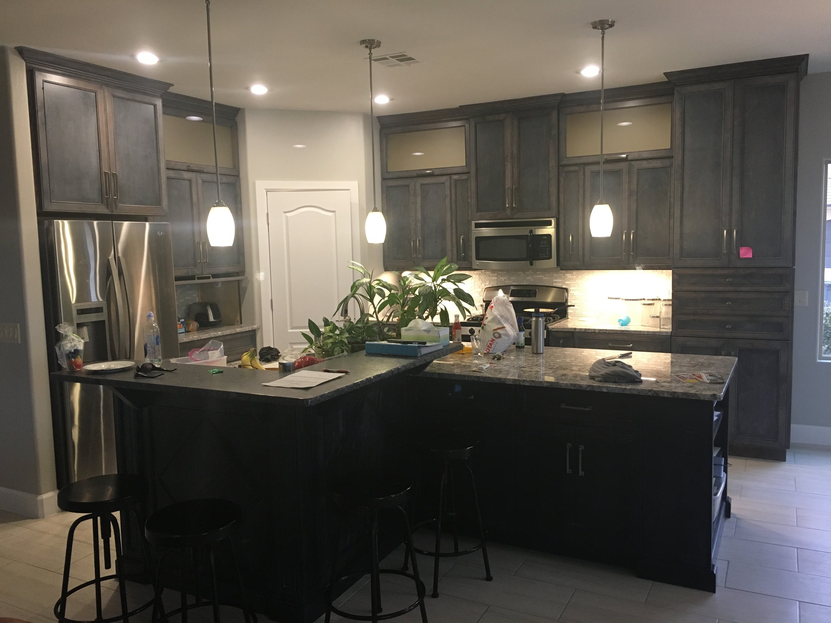 Dark custom kitchen with island and pendant lighting